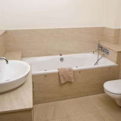 Most bathtubs are installed with some type of wooden frame that helps hold the tub in place, support it and hide the underside as well as any motor housing such as for whirlpool tubs. The vertical section, known as a skirt, can be covered by a wide variety of materials, ranging from tile to wood paneling to cultured marble and plastic sheeting or sheet metal. To build the skirt, the basic rules of house framing are used, and the overall frame supported with studs, footers and headers. Bathtub Wall Panels, Tub Surround Ideas, Plastic Bathtub, Bathtub Surround, Jetted Bath Tubs, Tiny House Talk, Bathtub Remodel, Bathtub Walls, Corner Tub