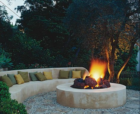 Designing with fire features: The fire sits in a 12-foot circle of flagstone and gravel, the same materials used for the path that winds up to this cozy hideaway. Rounded chunks of lava stone break up the sleek design giving the fire pit a more authentic, rustic feel. Photo by Tim Street-Porter. #gardendesign #autumn #firepit In Ground Fire Pit, Fire Pit Gallery, Bonfire Pits, Sunken Fire Pits, Fire Pit Materials, Outdoor Fire Pit Designs, Chill Zone, Fireplace Garden, Fire Pit Seating