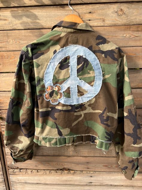 Super cute, slightly cropped, custom camo jacket with flower detailing on the front & peace sign detailing on the back! Camo Jacket With Patches, Camp Verde Arizona, Floral Peace Sign, Bohemian Twist, Patched Denim Jeans, Diy Denim Jacket, Repurposed Denim, Clothes Embroidery Diy, Custom Trucker Hats