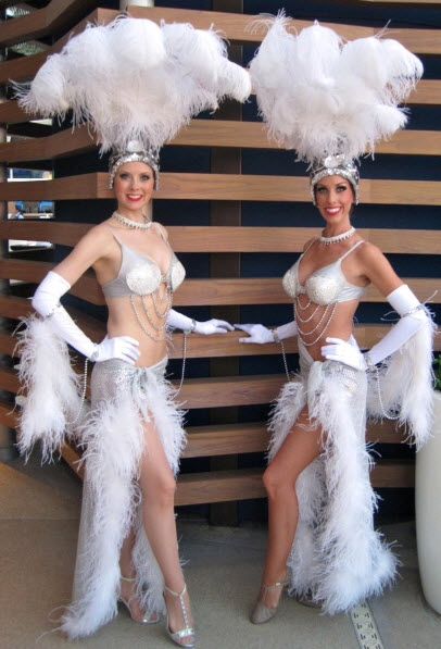 Beautiful showgirls in white costumes, complete with feather head dresses.  Great for guest photo ops with our personable and professional showgirls. Will add class and excitement to any party or trade show. Costumes come with G string look or covered up Sarong look. Comes in tall and regular height headpiece.  Includes model, costume & on-site mgmt. Vegas Showgirl Costume, Carnivale Costume, Moulin Rouge Costumes, Model Costume, Burlesque Fashion, Head Dresses, Showgirl Costume, Vegas Showgirl, Carnival Dress