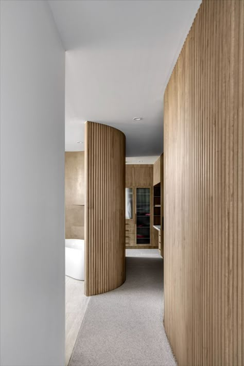 Project: Lakeland key by Evoque Interiors. A contemporay luxury walk in robe with a wet bar. #interiordesign #WIR #walkinrobe #tajmahal #wetbar #naturalstone #doorprofile #evoqueinteriors #australiandesign Timber Wall Feature, Internal Wall Cladding, Internal Cladding Ideas, Internal Wall Cladding Ideas, Curved Wall Paneling, Timber Cladding Interior Feature Walls, Timber Panelling Wall, Curved Feature Wall, Curved Wall Ideas