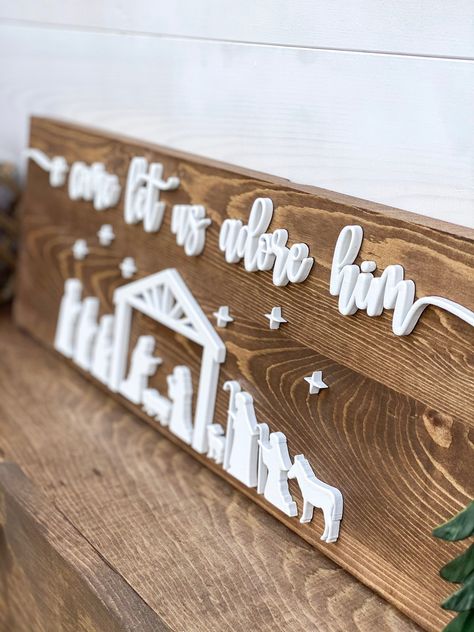 "Complete your holiday home decorating with this one of a kind Nativity Scene Sign that says \"O Come Let Us Adore Him\". This cute farmhouse sign comes with 3D lettering and will be a perfect addition to your Christmas Decor this holiday season or as a special Christmas gift for friends and family. Specifications: Size is 8x24 Medium Walnut Stained board with White 3D Lettering Production & Shipping: Please allow 2 weeks for production and 1 week for shipping." Cricut Farmhouse Signs Wood, Wood Holiday Signs, Nativity Wood Sign, Come Let Us Adore Him Sign, Cnc Router Christmas Projects, Christmas Plaques Ideas, O Come Let Us Adore Him Sign, Family Christmas Sign, Laser Engraving Christmas Ideas