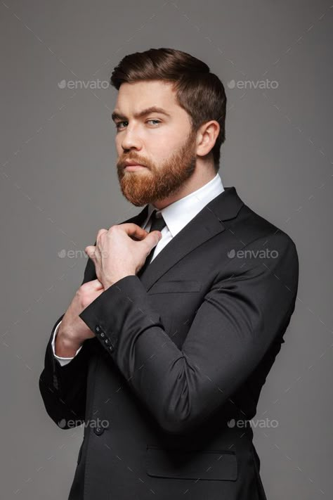 Portrait of a serious young businessman by vadymvdrobot. Portrait of a serious young businessman dressed in suit fixing his tie isolated over gray background #AD #vadymvdrobot, #dressed, #businessman, #Portrait Man Fixing Tie Reference, Fixing Suit Pose Reference, Fixing Tie Pose Reference, Fixing Tie Reference, Man In A Suit Reference, Man In Suit Pose, Poses With Suit, Fixing Tie Pose, Serious Pose Reference