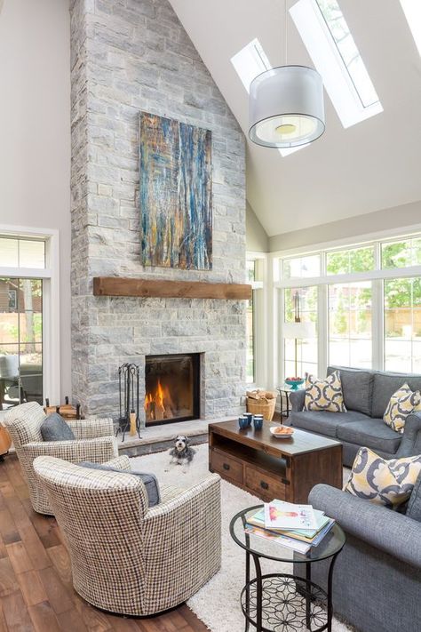 a clean double height neutral living room with a grey stone fireplace with a wooden mantel and a bright blue artwork Vaulted Ceiling Decor, Bright Ceiling, Custom Stone Fireplace, Grey Stone Fireplace, Vaulted Ceiling Living Room, High Ceiling Living Room, Family Living Room, Casa Country, Bright Living Room