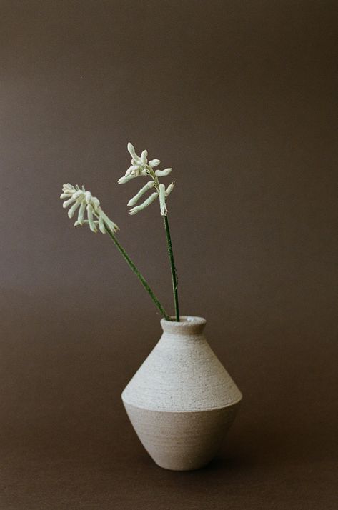 Echoing the striking silhouettes of Greek pottery, the Angular Ceramic Vase in Beige stands as a handcrafted marvel brought to life by skilled artisans in Europe. This multi-purpose vessel invites you to showcase its beauty by styling it with blooming buds or rustic branches. Due to its handmade nature, no two pieces are the same. Round Kitchen Table Styling, Pottery Vase Shapes, Ceramics Vase Ideas, Ceramic Planters Indoor, Vase Product Photography, Japandi Vase, Small Ceramic Vase, Angular Ceramics, Pottery Vase Ideas