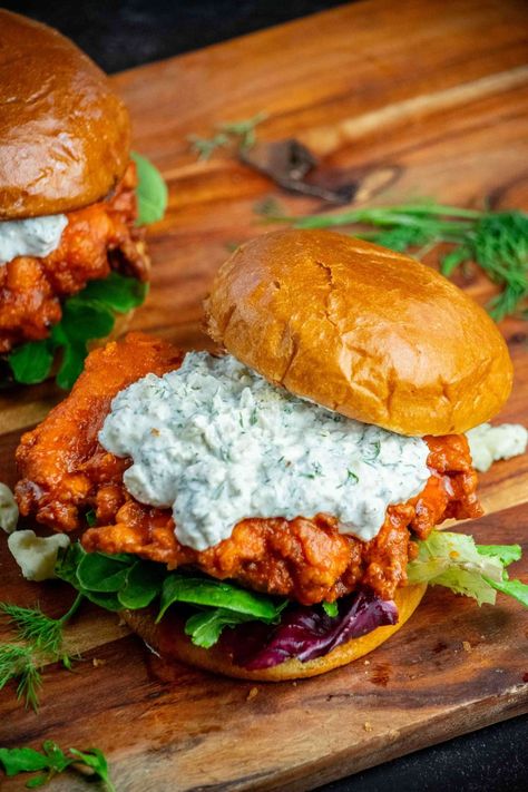 This crispy, crunchy, flavor-packed, buttermilk marinated buffalo chicken sandwich recipe uses a special ingredient for ultra-crispy breading, with a tangy homemade dilly blue cheese sauce and toasted brioche buns! Orange Chicken Sandwich, Blue Cheese Chicken Recipes, Crunchy Chicken Sandwich, Lunch Ideas Men, Feel Good Foodie Recipes, Chicken Burger Aesthetic, Buffalo Chicken Sandwich Recipes, Fried Buffalo Chicken Sandwich, Breaded Buffalo Chicken