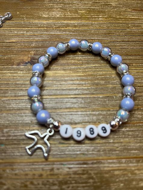 This bracelet was made with blue iridescent beads, silver spacers and a seagull charm.  The perfect way to celebrate 1989TV coming soon! For sizing help:  6 inches is considered a child or an adult X-small wrist. 6.5 inches is considered an adult small wrist. 6.75 inches is considered an adult medium wrist. 7 inches is considered an adult large wrist. 7.25 inches is considered an adult X-large wrist. Cinema Outfits, 1989 Bracelet, Eras Bracelet, Concert Bracelets, Friends Bracelet, Photos Of Taylor Swift, Cute Friendship Bracelets, Friendship Songs, Preppy Bracelets