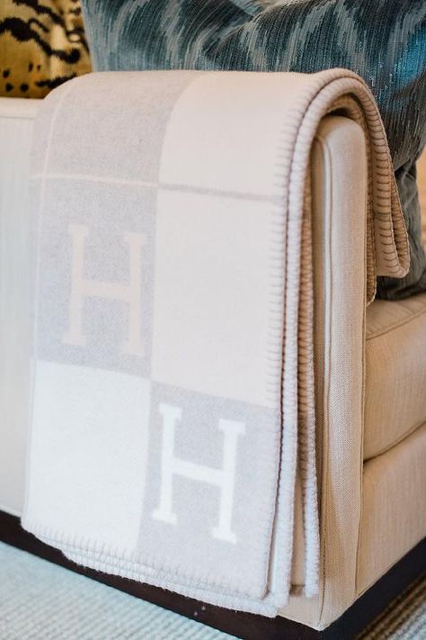 Ivory sofa in a living room accented with a light gray Hermes blanket bringing the perfect finish to the transitional design. Ivory Sofa, Nailhead Sofa, Hermes Blanket, Hermes Home, Antique Brass Floor Lamp, Black Couches, Striped Sofa, Fringe Rugs, Purple Pillows