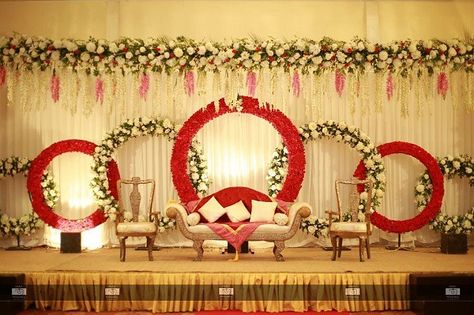 Floral rings Engagement Stage Decor  #wedding_chicks #engagementstage #stagedecor #engagementdecorations #engagementstagedecorations #decorations #decor #weddingdecor #indianweddingdecor #decorationforengagement #stagedecorstions Engagement Stage, Indian Wedding Stage, Indian Wedding Decorations Receptions, Engagement Stage Decoration, Reception Stage Decor, Wedding Stage Backdrop, Wedding Hall Decorations, Wedding Stage Decor, Wedding Background Decoration