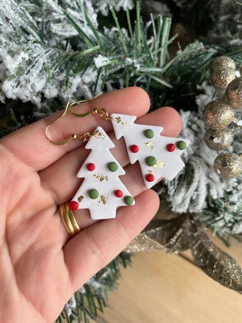 These gorgeous handmade polymer clay earrings feature an elegant white Christmas tree, with the traditional red and green "baubles", as well as gold foil throughout. They are paired with gold plated, tarnish resistant hooks. Christmas Tree Clay, Fimo Christmas, Tree Clay, Christmas Tree Handmade, Cricut Christmas Ideas, Holiday Inspo, Tree Handmade, Handmade Clay Jewelry, Cricut Christmas