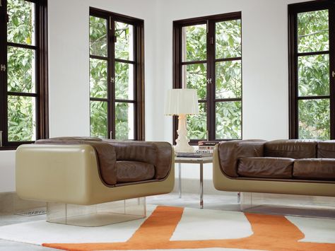 Living Room, Chair, and Sofa To highlight the existing architecture of the home, Hill retained the dark polish of the casement windows, which she finds enhances period details instead of undermining them. In the rear sunroom, the vintage Case Study furniture pieces with Plexiglas bases are from Metro Retro in Houston. A Bourgie lamp by Kartell is atop an old marble end table by Knoll, and the Gan kilim rug pictures a branch motif echoed in the kitchen and breakfast room. Photo 2 of 9 in A Design Brown Window Frames, Traditional Minimalist Home, 1920s House, Minimalist Home Interior, Atlanta Homes, Window Frames, Minimalist Home, Furniture Makeover, Modern Living Room