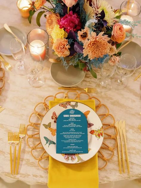 1960s Table Setting, Rattan Charger Plates Wedding, Butterfly Wedding Ideas, Retro Shoot, Rattan Charger, Dyed Flowers, Yellow Napkins, Blue Dinner, Renewal Wedding