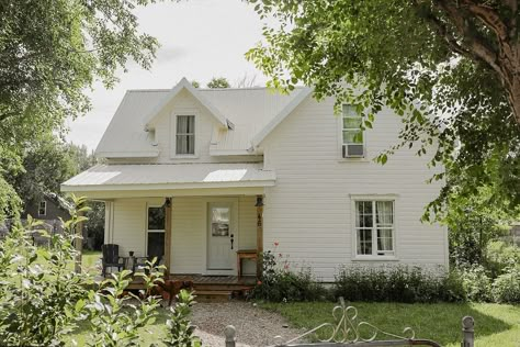 We bought the house two years ago come August, had three weeks to renovate and move in, and have been working on her ever since. The front door was a spare Pop had from a job, the porch was built from leftover deck materials that were warped. The stone path was made by foraging down by the river and loading stones back and forth with Ma and the kids. The lawn was a dirt pit and took hours upon hours of raking, sifting, adding new dirt, seeding, adding more dirt, and patience. The upstairs sin... Farmhouse In The Woods, Old Farmhouse Exterior, Farmhouse Exterior Paint Colors, Farmhouse Colonial, Dream Farmhouse, Prairie Home, Small Farmhouse, Stone Path, Countryside House