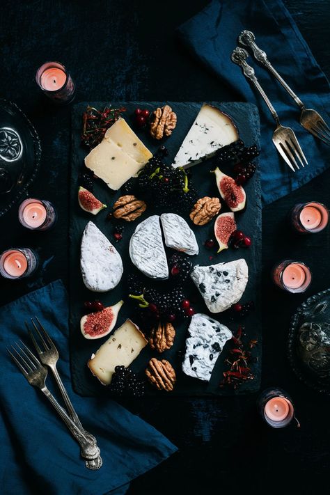 A black slate cheese board adorned with various cheeses, dark berries, figs, and walnuts, accented with antique silverware and surrounded by gothic candles and moody lighting. Gothic Charcuterie Board, Black Charcuterie Board, Cheese Board Ideas, Vampire Party, Slate Cheese Board, Dark Elegance, Black Inspiration, Food Coma, Wine Art