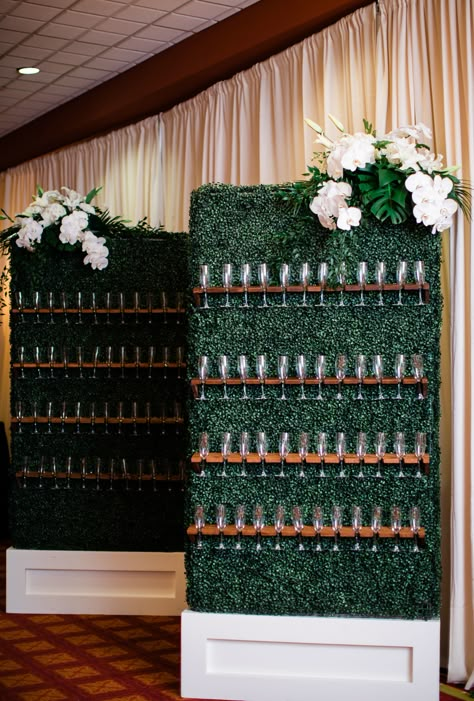 Boxwood greenery walls with floral arrangements and champagne flutes resting on shelves. Formal Gala Decor, High End Party Decor, Boxwood Champagne Wall, Minimal Event Decor, Nature Event Decor, Corporate Gala Decor, Prom Event Decor, Cooperate Event Decoration, Event Props Decor