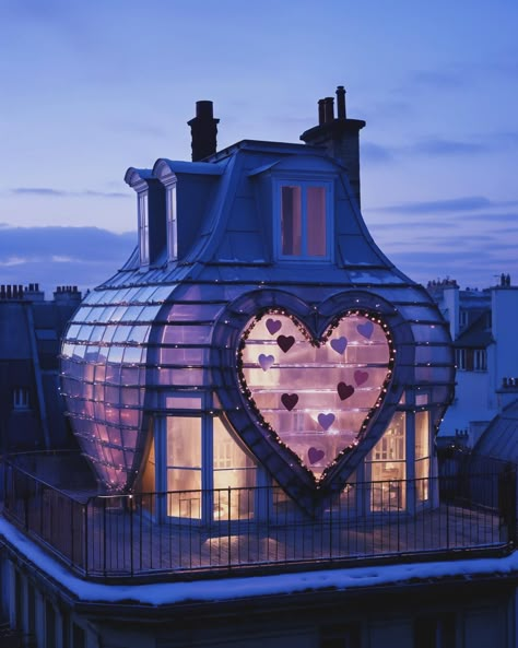 Did you know that some houses in Paris have heart-shaped windows on their top floor? Imagine strolling through the charming streets of Paris, gazing up at the facades, all unique with quite literal heartwarming details. In a hidden warehouse in the middle of the city, you can find a vendor of these windows. On Valentine’s Day, couples, singles, mothers and children, and brothers and sisters come together to pick out a window. Because love is for everybody. AI-generated, edited and enhanced ... Queen Of Hearts Aesthetic, Houses In Paris, Heart City, Architecture Pictures, Hearts Aesthetic, Heart House, Heart Window, Castle Floor Plan, Solar Return