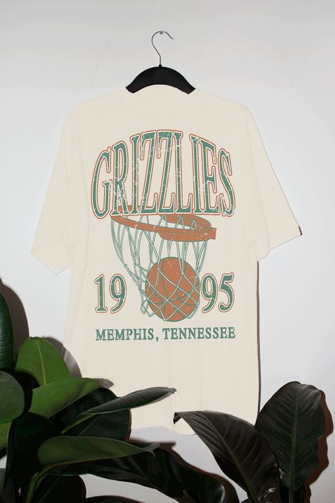 Show the love for your favorite team in this Memphis Basketball oversized tshirt that is inspired by vintage 90s NBA tshirts!- Screen print transfer that is heat pressed onto each tshirt- Tshirt is a super soft vintage wash that gets softer after each wash- Oversized fit- Sizing translation: XS/S = L , S/M = XL , L/XL = 2XL , 2XL/3XL = 3XL , 4XL/5XL = 4XL- Size up if you want a tshirt dress fit- 100% Cotton**due to screens & filters color may vary from pictures** Vintage Basketball Tee, Vintage Sports Shirts, Vintage Basketball Shirt, Vintage Sports Tees, Team Tshirt Design, 90s Tshirt Design, Oversized Graphic Tee Outfits, Basketball Team Shirts, 90s Graphic Tees Vintage