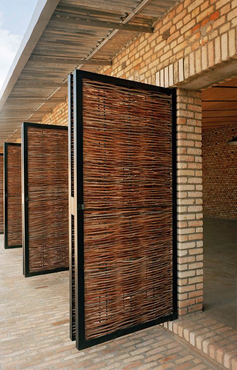 Dominikus Stark’s Education Center in Rwanda. Brickwork is combined with wickerwork and steel door and window surrounds. (Architonic.com) Bamboo Privacy Wall, Bamboo Door, Bamboo Architecture, Facade Lighting, Bamboo House, Brick Architecture, Vernacular Architecture, Courtyard House, Building Facade