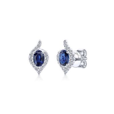 Add a dramatic splash of color and sparkle to your ensemble with these sapphire and diamond earrings. Brilliant .24ct pave diamonds set in 14 white gold form a modified pear shaped halo around regal oval cut sapphires. 14k White Gold Diamond Halo Oval Cut Sapphire Stud Earrings | EG13116W44SA Engagement Rings | Fashion Jewelry | Gabriel NY #diamondearrings #sapphireearrings #uniqueearrings Fine Jewelry Sapphire Earrings With Halo Design, Oval Sapphire Earrings, Sapphire Halo Earrings Fine Jewelry, Sapphire Oval Diamond Earrings, Blue Sapphire Oval Diamond Earrings, Luxury Sapphire Earrings With Halo Setting, Sapphire Earring, Light Blue Sapphire, Sapphire Stud Earrings