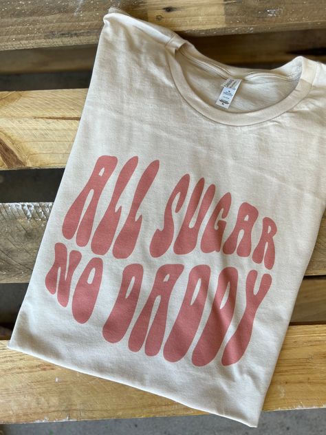 "All Sugar No Daddy" Graphic Tee Cream & White Colors Super Soft & Stretchy Cotton Tee Unisex Cut ~ Runs Roomy ~ If You Want A More Fitted Tee We Recommend You Size Down Women's Sizing Recommendations Small 0/2/4 Medium 4/6/8 Large 8/10/12 XL 12/14/16 2XL 16/18/20 3XL 20/22/24 ***These Are PRINTED/MADE TO ORDER! Please Allow 7-10 Business Days To Ship. If You Order Multiple Items, These Will Be Shipping Out SEPARATELY From Your Order. Graphic Tee Sayings, Graphic Tees Preppy, Fun Tshirt Designs, Cricut Tee Shirt Ideas, Graphic Tee Ideas, Small Business Shirt, Cut Shirt Designs, Charlie 1 Horse Hat, Monogram Outfit