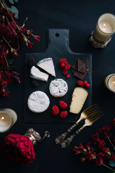 Black slate cheese board with brie, gouda, dark chocolate, raspberries, and blackberries, surrounded by antique gold cutlery and deep red flowers, illuminated by soft candlelight. Cheese Board Ideas, Slate Cheese Board, Gothic Aesthetic, Board Ideas, Dark Aesthetic, A Black, Cheese Board, Cheese, Black