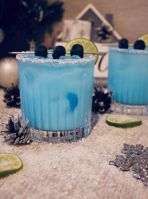 Imagine you are spending Christmas on a tropical island while sipping this refreshing cocktail. The ultimate festive drink that combines a creamy coconut milk, fresh lime juice, blueberries, Blue Curaçao liqueur and a shot of Russian Standard vodka. #coktailrecipe #cocktailideas #cocktail #cocktails #christmascocktails #festivecocktails Blue Curacao Christmas Drinks, Tropical Christmas Drinks, Blue Christmas Cocktails, Light Blue Cocktails, Blue Vodka Cocktails, Blue Cocktail Drinks, Coconut Vodka Cocktails, Christmas Cocktails Vodka, Blue Curacao Drinks