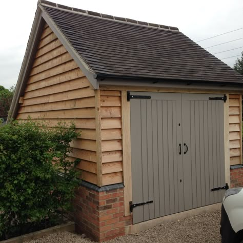 Oak frame garage, larch cladding and brick plinths, farrall and ball paint work. By R J Heathcote.co.uk Carpentry/joinery Leicestershire  Ashby de la zouch Cottage Garage Ideas, Garden Garage Ideas, Garage Cladding Ideas, Wooden Shed, Garden Garage, Brick Garage, Garage Shed Ideas, Cladding Garage, Wooden Garages