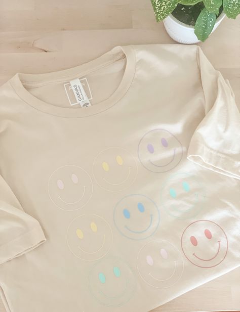 Introducing our Retro Smiley T-Shirt, the perfect blend of nostalgia and contemporary style for those seeking a touch of vintage charm. This t-shirt is more than just a fashion item; it's a conversation starter and a way to express your individuality. Whether you pair it with jeans for a casual outing or layer it under a blazer for a trendy twist, the Retro Smiley T-Shirt effortlessly adds a touch of retro coolness to your ensemble. Get yours today and let your style do the talking! Trendy Cotton T-shirt With Smiley Face, Cheap Short Sleeve T-shirt With Smiley Face, White Playful T-shirt With Smiley Face, Fun Smiley Face Short Sleeve T-shirt, Smiley Face Tshirt, Spring Smiley Face Short Sleeve T-shirt, Smiley Face Shirt, Good Vibes Shirt, Face Aesthetic