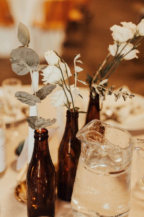 Wedding Growler Centerpiece, Wine Bottle Bud Vase Wedding, Beer Bottle Vases Wedding, Flowers In Beer Bottles Wedding, Bottle Vases Wedding, Brown Bottle Vase Wedding, Beer Bottle Vase, Beer Bottle Centerpieces, Eucalyptus Diy