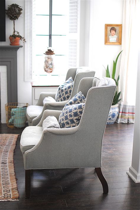 This living room is fierce. Love these chairs and the pillows! check out the details on bottom of the curtains. Love the touch of coral. Styling Wingback Chairs, Wing Back Chairs Living Room, Pretty Chairs, Wingback Chair Living Room, Cozy Chairs, Fireplace Area, Wing Chairs, Wingback Chairs, Herringbone Fabric