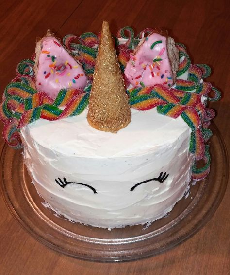 Easy homemade unicorn cake. No fondant needed. I used two box cakes, baked in 9" pie pans and stacked. One box of cake mix makes two 9" cakes, this is four layers. It is made with normal store bought icing. The horn is an ice cream cone brushed with melted butter and covered in gold sprinkles. The hair is made of Air Heads Extreme candy twisted into curls. The ears are two cut sprinkle pink donuts from Shipley's. The eyes are just a bit of black decorative icing. Unicorn Ice Cream Cake, Ice Cream Cone Ideas, Homemade Unicorn Cake Easy, Ice Cream Cone Unicorn Horn, Decorative Icing, Unicorn Tray Bake Cake, Meringue Unicorn Horn, How To Make A Unicorn Horn For A Cake, Store Bought Icing