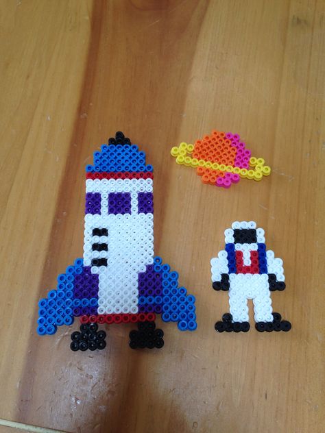 Perler beads rocket, astronaut and planet Rocket Perler Beads, Outer Space Perler Bead Patterns, Perler Beads Space, Space Perler Beads, Space Perler Bead Patterns, Hama Bead, Hamma Beads Ideas, Fusion Beads, Easy Perler Bead Patterns