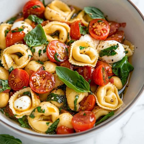 This Tortellini Caprese salad is perfect for summer potlucks, picnics, and barbecues. The combination of cheese tortellini, tomatoes, mozzarella, and basil is simply irresistible. Mozzarella Balls Pasta Salad, Simple Caprese Tortellini Salad, Caprese Tortellini Pasta Salad, Tortellini Recipes Salad, Tortellini Caprese Salad, Hoco Dinner, Salad Dressing Recipes Vinaigrette, Week Day Meals, Cheese Tortellini Recipes