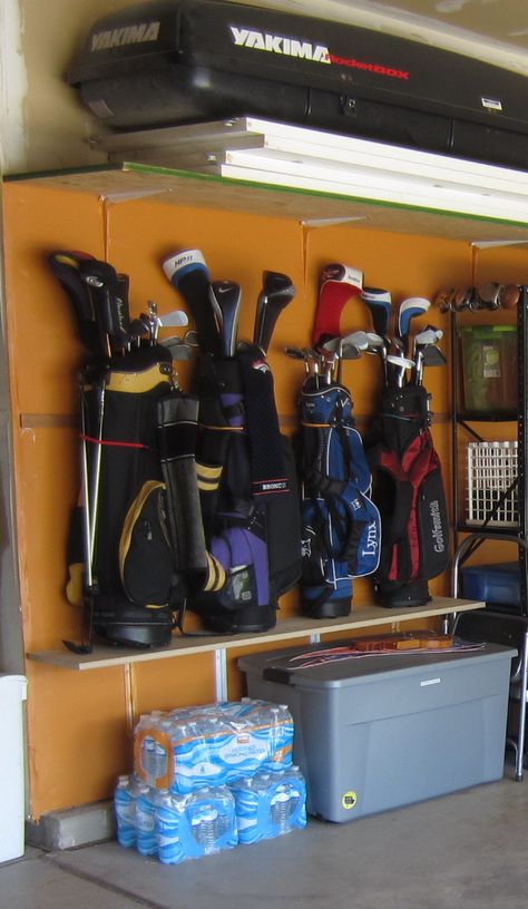 My golf club storage -  inexpensive solution to using the vertical space in the garage. Using bungee cords attached to the wall to hold them (similar to the strap on the back of a golf cart). Garage Organization Golf Clubs, Garage Golf Organization, Storing Golf Clubs In Garage, Garage Golf Storage Ideas, Golf Club Storage Ideas, Golf Storage In Garage, Garage Golf Storage, Golf Club Storage Garage, Golf Bag Storage Diy