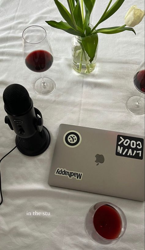 A white table with a laptop, wine glasses filled with red wine, a vase of tulips, and a black microphone. Podcast Aethestic, Podcast Recording Aesthetic, Recording A Podcast, Successful Podcast Aesthetic, Social Media Work Aesthetic, Starting A Podcast Aesthetic, Podcast Microphone Aesthetic, Podcast Aesthetic Wallpaper, Vision Board Podcast