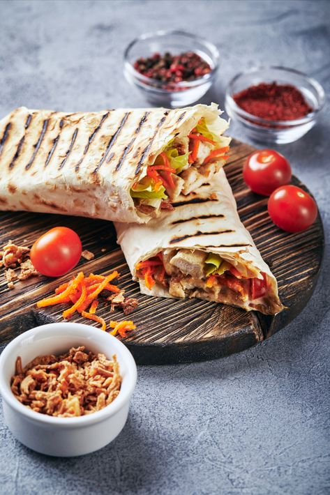 To make this shawarma, the meat is placed on a flatbread with vegetables such as lettuce, tomatoes, and onions, then topped with sauces such as tahini, garlic, or hot sauce. The sandwich is then wrapped and served warm. The key to a delicious shawarma is in the marination and spices used for the meat, as well as the selection and balance of sauces to complement the flavors. Satisfying Food, Flatbread, Healthy Options, Tahini, Hot Sauce, Aesthetic Food, Onions, Lettuce, Food Inspiration