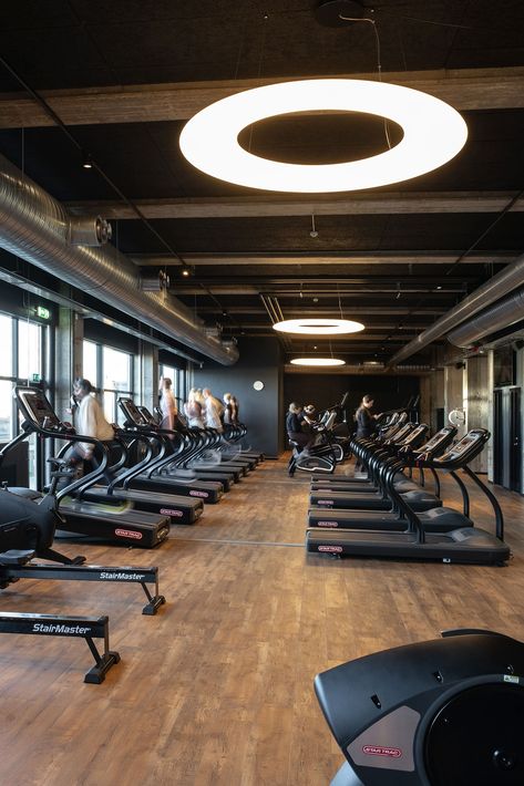 Black Troldtekt acoustic panels cover the ceiling in this urban gym. The raw materials and the concrete structure of the building is thereby supported by a solid structured soundscape within an elsewhere noisy environment. Click the link on the picture to see more. #goodacoustics #holzwolleplatten #träullsplattor #troldtekt | Architects: Ejendomsselskabet Olav de Linde Gym Place Interior Design, Dark Ceilings, Wood Wool Panels, Engineering Office, Round Light Fixture, Acoustics Design, University Of York, Gym Plans, Dark Ceiling