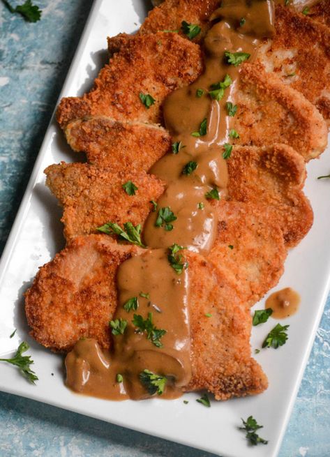 A delicious pork schnitzel recipe is just the thing you need to jazz up dinner! Bathed in a delicious brown gravy, pork schnitzel is not just another boring pork chop. Making this delicious dinner is a snap and results in a meal your whole family will love! Schnitzel Gravy Recipe, Pork Snitzel, German Pork Schnitzel, Pork Schnitzel Recipe, Brown Gravy Recipe, Schnitzel Recipe, German Food Authentic, Schnitzel Recipes, Pork Chops And Gravy