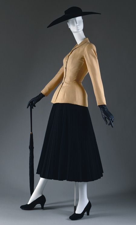 1947 Dior suit iconic of the "New Look" that would carry into the 50's.  Padded hips, articulated bustline and nipped waist.  Unlike the similar silhouette of the mid nineteenth century, the figure was expected to fit this silhouette through internal methods, ie dieting, rather than restrictive corsets.  Brassiere's and elastic girdles were worn instead.  Even waist cinchers of the 50's were only 4 inches wide. Dior New Look, Jacques Fath, 1950’s Fashion, Fashion 1940s, Vintage Suit, Carmen Miranda, Christian Dior Haute Couture, Dior Vintage, Dior Haute Couture