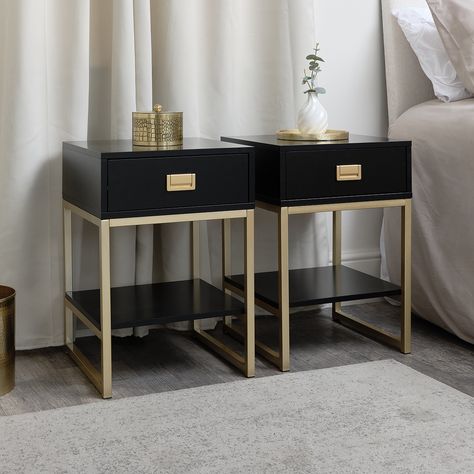 This Pair of One Drawer Bedside Tables from the Elle Black Range are a striking  contemporary storage choice for placing in a bedroom  dressing room or living room space. Crafted from coated MDF and metal  each bedside table has a one drawer  one shelf design and a metal frame. This bedside has a black finish  a gold frame and matching gold handles.   A sleek modern furniture set with a timeless  eye catching design  this pair of bedside tables are as stylish as they are practical and space saving. Their compact size and excellent storage capabilities make them an attractive storage option for minimalists and luxury lovers alike.  This product is also available in stone  white  pink and grey. Matching items are available in this collection. Please Note: This item requires assembly. It will Sleek Bedside Table, Hotel Room Bedside Table, Black Pink And Gold Bedroom, Black Gold Bedroom, Gold Nightstand, Iron Furniture Design, Bedroom Dressing Room, Contemporary Storage, Black Range