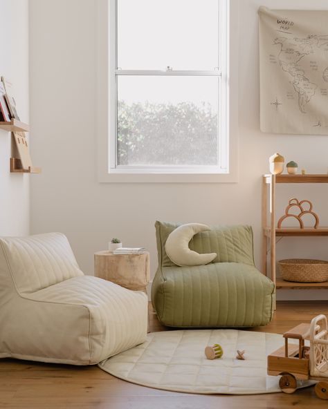 Playroom with wooden floors and white vegan leather Wipeable playmat with two beanbag vegan leather lounge chairs in white and sage green. Minimalist vibe with wooden toys and Montessori inspired shelving Modern Boho Playroom, Kids Playroom Aesthetic, Kids Room Play Area, Cozy Playroom Ideas, Beige Playroom, Neutral Toddler Boy Room, Neutral Playroom Ideas, Nordic Playroom, Chic Playroom