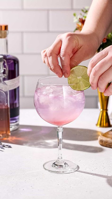 This Lavender Lime Gin Spritz is a delicious, refreshing and colorful drink, perfect for a spring or summer sip! The floral flavor of lavender goes perfectly together with the lime and gin. Using Empress gin gives a lovely purplish pink color to the drink. Great for a garden party, bridal shower or just sipping poolside! Lavender Sour Cocktail, Lavender Gin Fizz Recipe, Lavender Haze Cocktail, Lavender Gin Fizz, Lavender Gin, Empress Gin, Easy Drinks To Make, Lavender Cocktail, Garden Party Bridal Shower