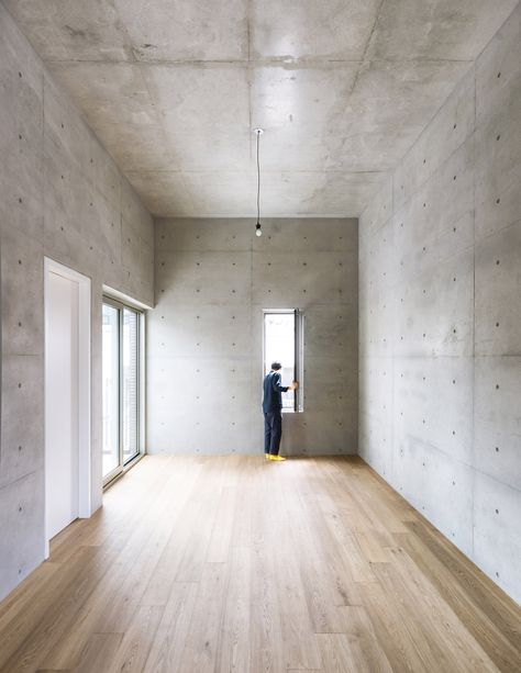 The inside of this building is finished minimally with reinforced concrete walls left mainly exposed throughout. Just a few are plastered and painted white. Concrete Home Interior, Concrete Walls Interior, Concrete Interiors, Concrete Ceiling, Concrete Houses, Concrete Walls, Concrete Architecture, Concrete Home, Exposed Concrete