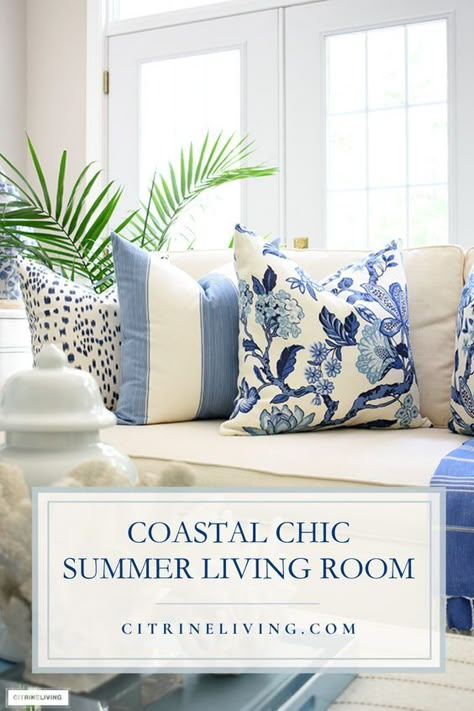 Preppy coastal chic is a classic, crisp way to dress up your living room! Create a stunning look with gorgeous prints layered with throw pillows, blankets and accented with all things coastal: lush palms and coral sculptures mixed in with a blue and white palette is always coastal chic! See more tips + learn how to create a stunning coastal haven here: https://citrineliving.com/coastal-chic-summer-living-room-decor/ Blue Southern Living Room, Preppy Coastal Living Room, Blue And White Living Room Throw Pillows, Nantucket Coastal Style, Coastal Floral Decor, Blue And White Living Room Decor Ideas, Blue Accent Living Room Decor, Summer Decor Living Room, Summer Home Decor Ideas Living Rooms