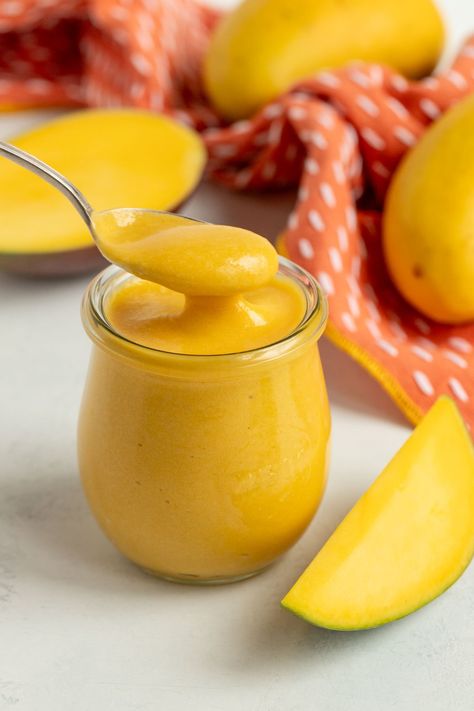 Mango curd in a pint jar with a spoonful of curd hovering over the top of the jar.  Fresh mangos are in the background Mango Gelee, Mango Decoration, Mango Curd Recipe, Milk Curd, Mango Curd, Mango Sauce, Jam Recipes Homemade, Pie Filling Recipes, Mango Puree