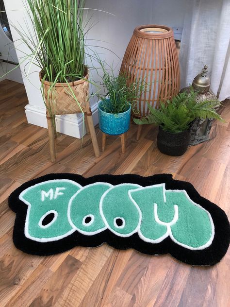 OFF THE CUT studios presents the MF DOOM rug. This rug is the perfect way to create an eye-catching, unique style to your space. This rug is 30cmx70cm. Bigger sizes can be requested if you send over a message to discuss the dimensions you require and new pricing.  This rug can also function as a wall hanging, so upon purchase send a message and we will send a free velcro hanging kit with the rug (Which is also renter friendly)! All rugs are made using 100% acrylic yarn and sprayed with a fabric Cool Stuff For My Room, Cool Stuff To Put In Your Room, Cool Bedroom Rugs, Rug Ideas For Bedrooms, Mf Doom Rug, Cool Room Stuff, Hiphop Rug, Wall Rug Hanging, Cool Rugs For Bedroom