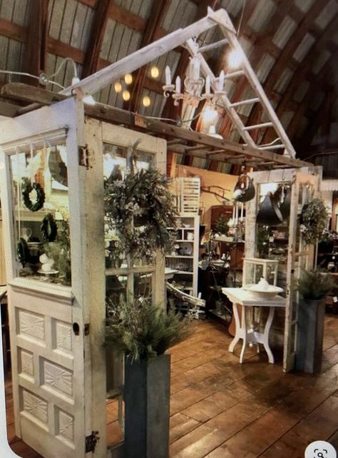 Wreath Market Display, Vintage Booths Ideas, Rustic Shop Display, Antique Fair Booth Display, Spring Retail Display Ideas, Garden Flag Display Ideas Retail, Farmhouse Vendor Booth Display Ideas, Vintage Store Displays Boutiques, Small Shop Interior Design Retail