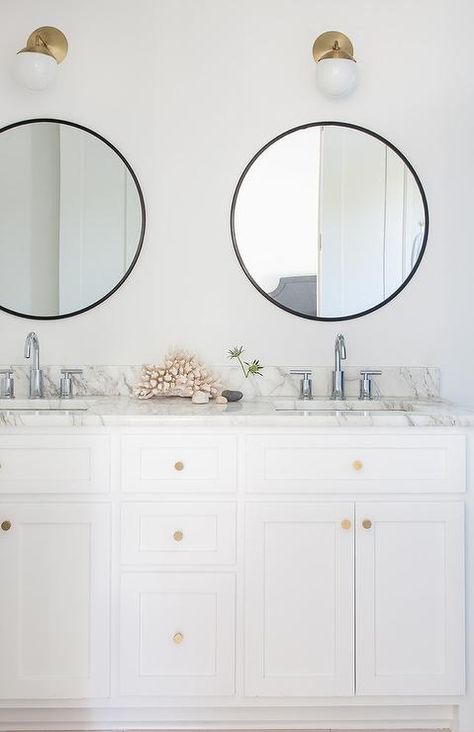 White and black bathroom features a white dual washstand adorned with brushed brass knobs topped with gray and white marble fitted with his and hers sinks and polished nickel faucets placed under round black mirrors and white glass and brass globe wall sconces, Cedar & Moss Alto Sconces. Houzz Bathroom, Mirrors Ideas, Polished Nickel Faucet, Mirrors Bathroom, Mixing Metals, Room Mirror, Transitional Bathroom, Chrome Faucet, Chrome Bathroom