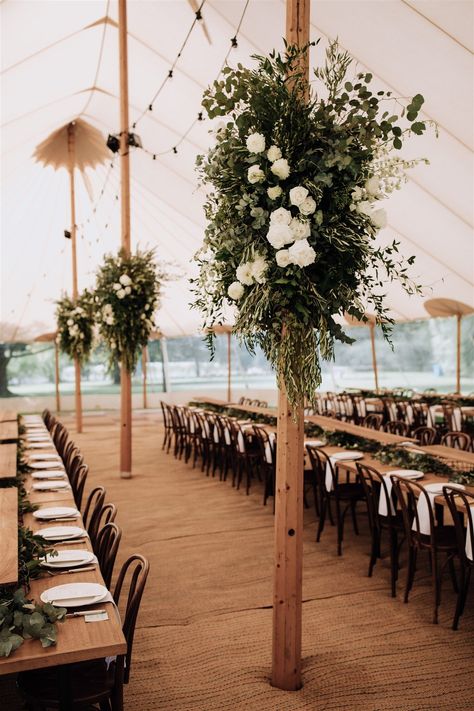 Bring the outdoors in by adding stylish floral decoration on the upright poles. Lush foliage base with seasonal white floral inclusions- perfect for a pop up wedding. Tent Pole Greenery, Wedding Marquee Flowers, Wedding Marquee Entrance Flowers, Barn Wedding Hanging Flowers, Marquee Poles Foliage, Hanging Marquee Flowers, Marquee Decor, Pop Up Wedding, Marquee Decoration