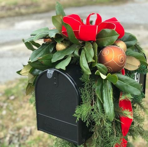 A black mailbox decorated for the holidays with gold Christmas balls, red ribbon and lots of greenery including magnolia and cedar leaves Mailbox Swag Christmas, Christmas Mailbox Swag, Christmas Mailbox Decorations, Yuletide Decorations, Mailbox Swag, Christmas Mailbox, Diy Mailbox, Swag Ideas, Mailbox Decor